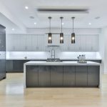 Modern kitchen with grey cabinets and a white island