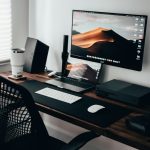 Home office workspace with a laptop, monitor and keyboard on a wooden desk