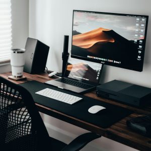 Home office workspace with a laptop, monitor and keyboard on a wooden desk
