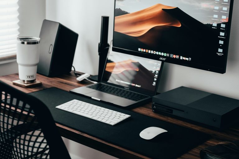 Home office workspace with a laptop, monitor and keyboard on a wooden desk