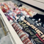 A drawer filled with neatly rolled folded clothing