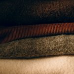 Stack of folded wool jumpers in neutral colours