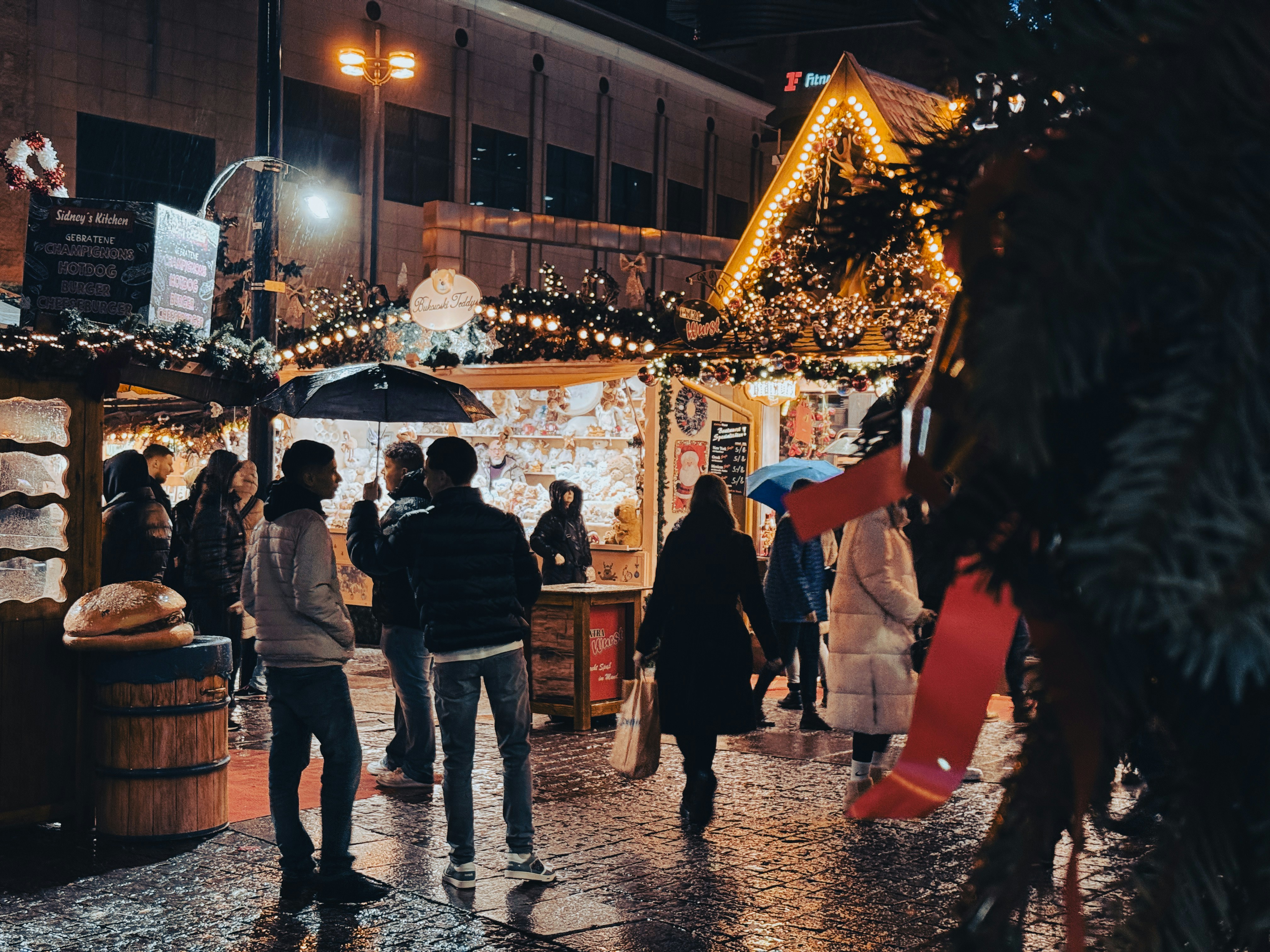 People walking through a festive German Christmas market at night