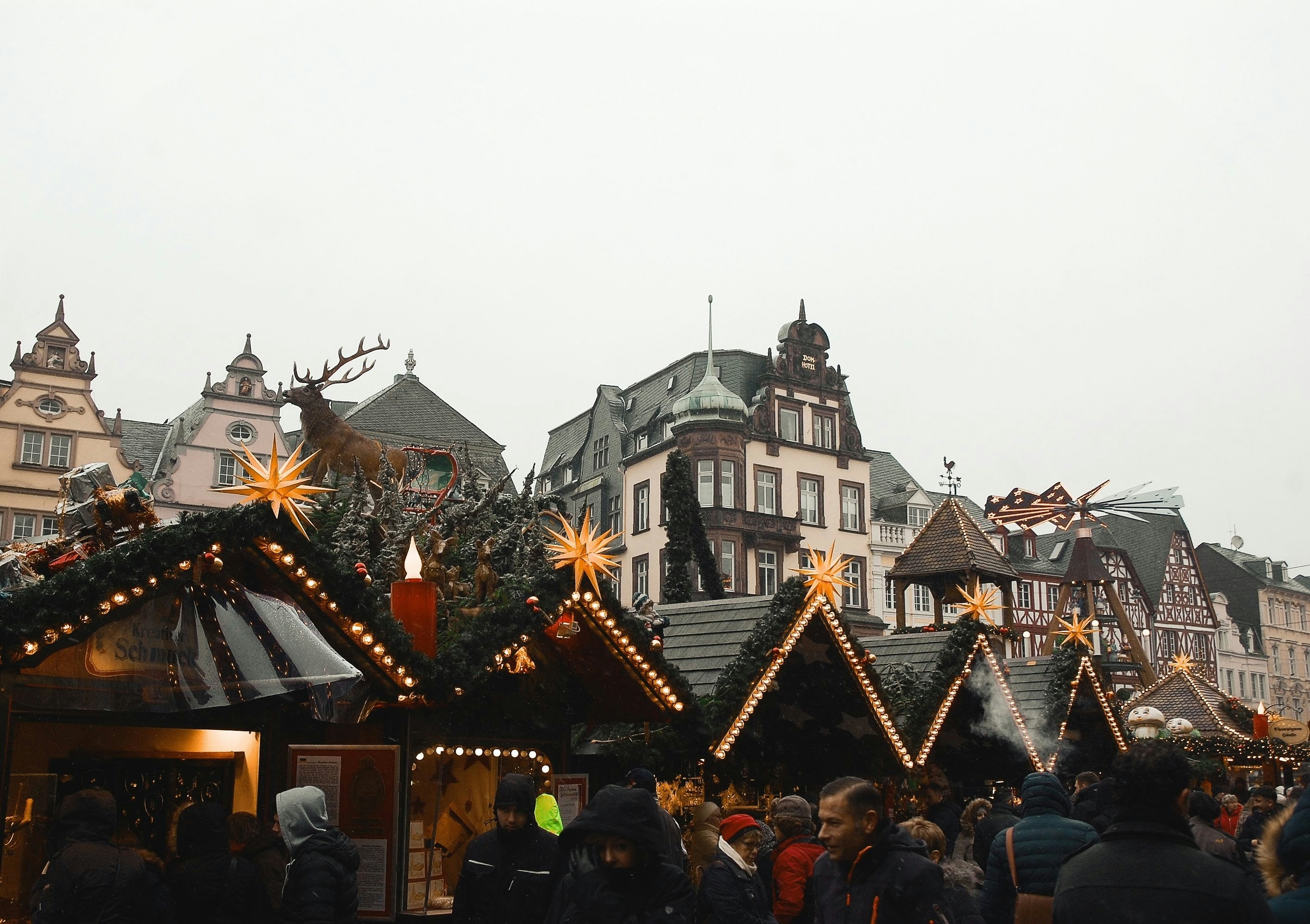 Visitors walking past wooden Christmas market stalls